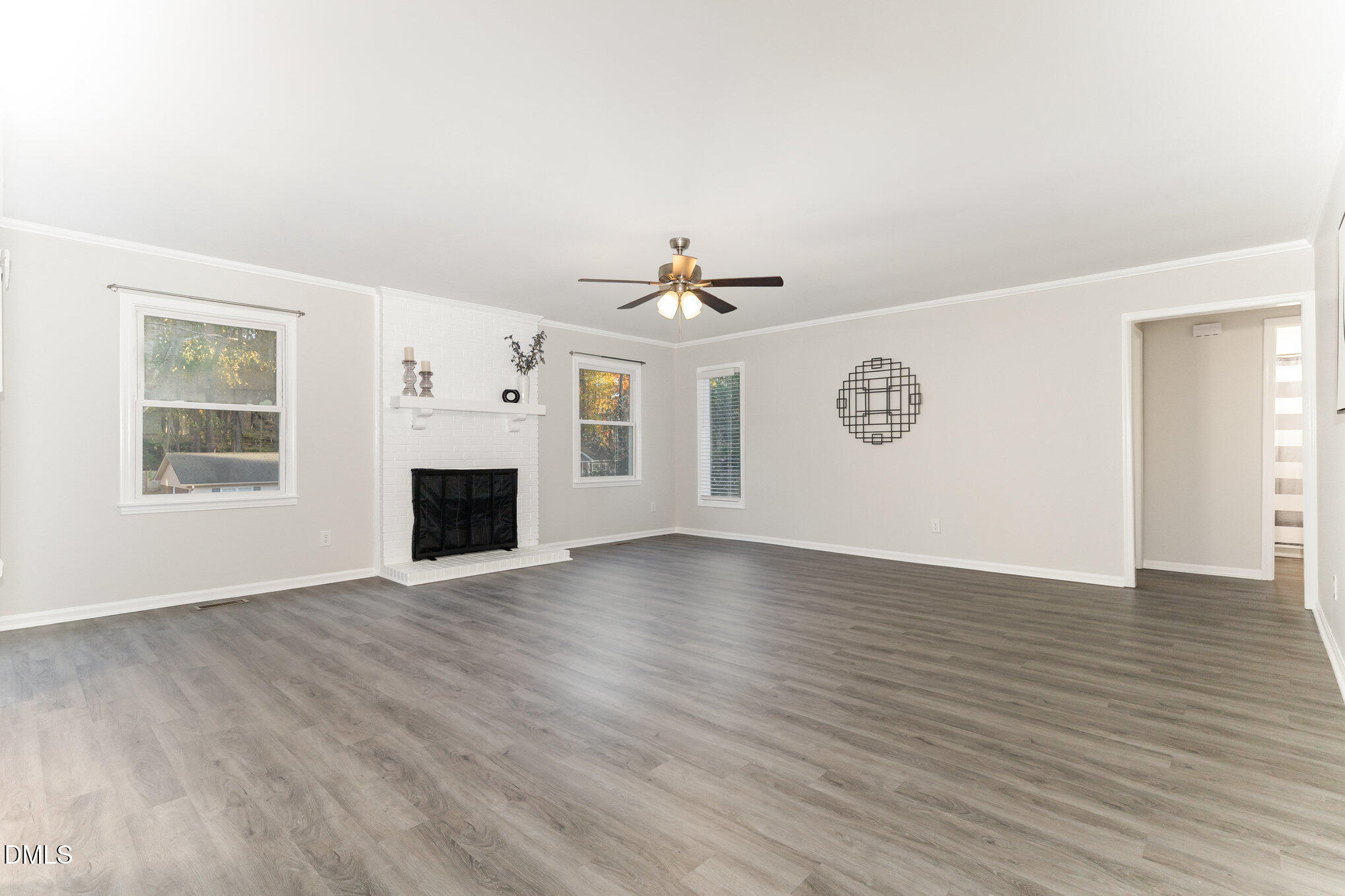 7717 Cart Track Trail Raleigh, NC 27615 - Photo 4 of 18 an empty room with wooden floor a ceiling fan and windows