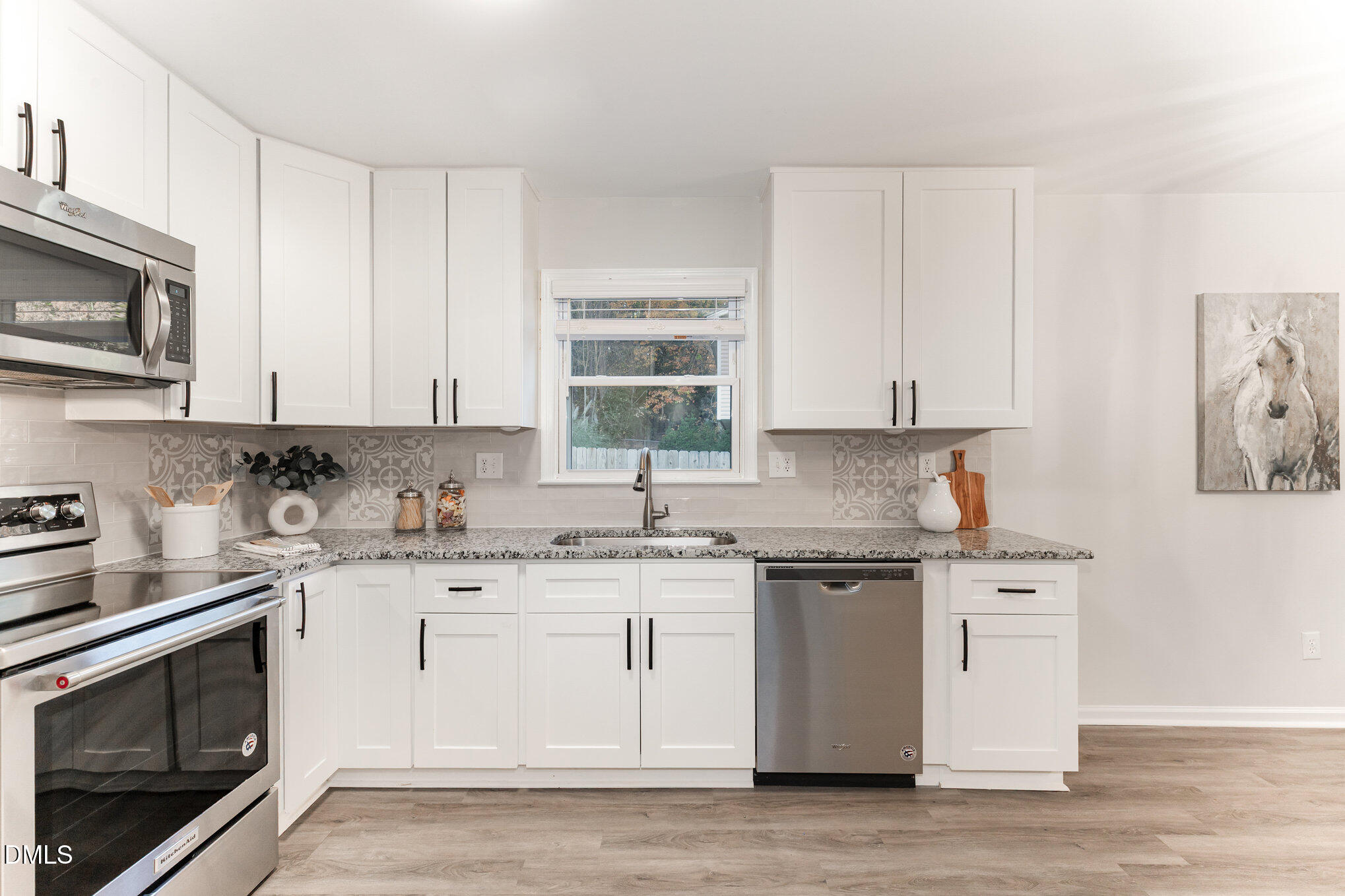 7717 Cart Track Trail Raleigh, NC 27615 - Photo 10 of 18 a kitchen with stainless steel appliances granite countertop white cabinets a sink a stove a microwave and cabinetry