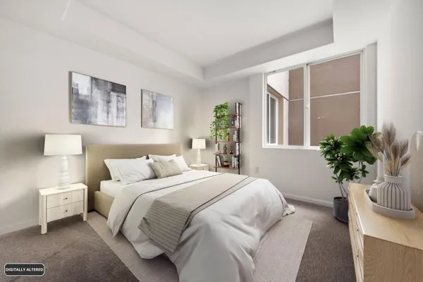 a bedroom with a large bed and a potted plant