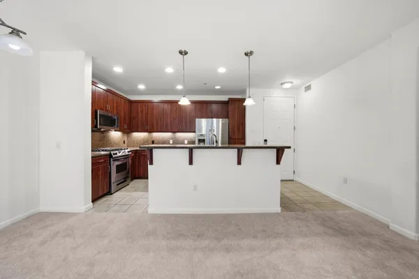 a kitchen with stainless steel appliances granite countertop a stove a sink and a refrigerator