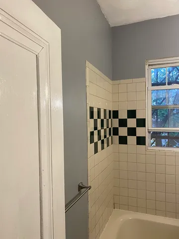 a view of a small space with wooden floor and a window