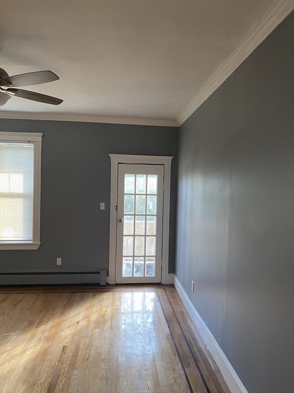 39 Pasadena Road, Unit 2 Boston, MA 02121 - Photo 10 of 29 an empty room with wooden floor and windows