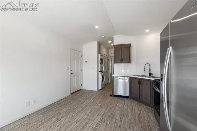 a kitchen with stainless steel appliances granite countertop a refrigerator and a stove top oven