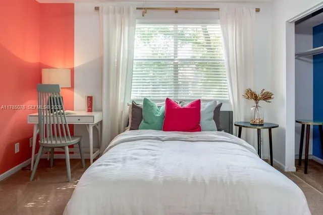 a large bed sitting in a bedroom next to a window