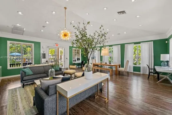 a living room with furniture a large window and wooden floor