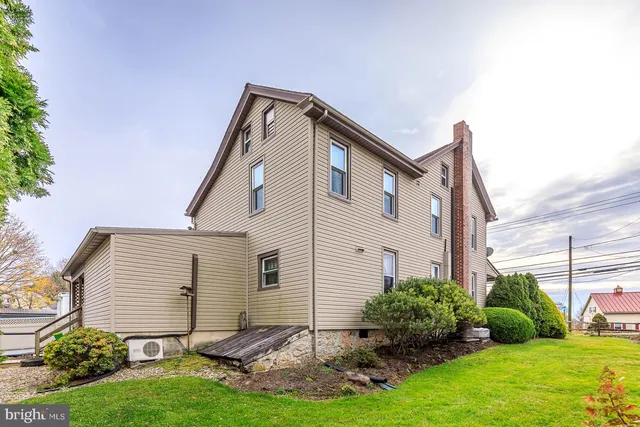 a front view of a house with a tree