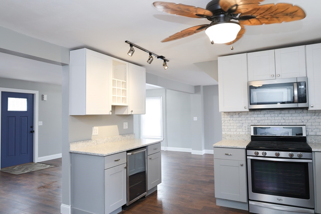 152 Central Street Georgetown, MA 01833 - Photo 7 of 26 a kitchen with granite countertop a stove cabinets and microwave