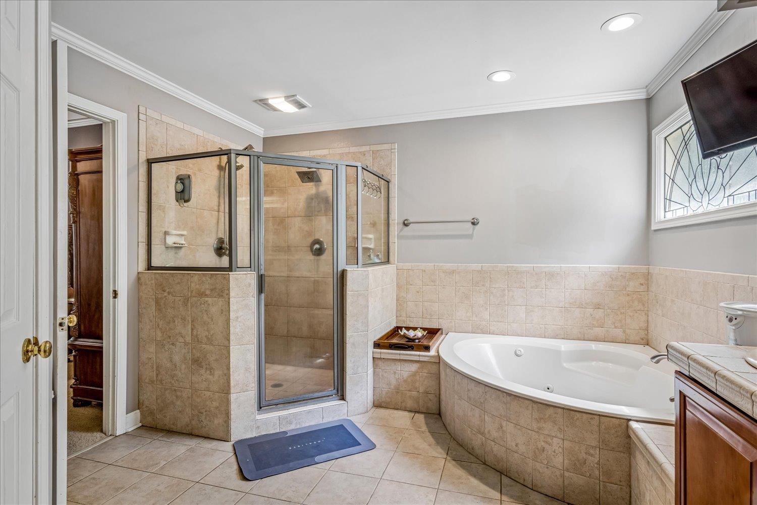 65 Summer Grove Road Memphis, TN 38018 - Photo 26 of 38 Tiled walk-in shower with a glass enclosure, corner soaking tub, and crown molding