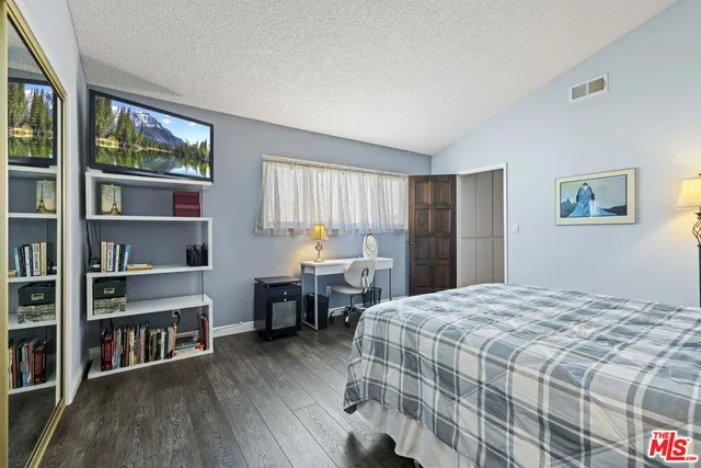 a bedroom with a bed furniture and a book shelf