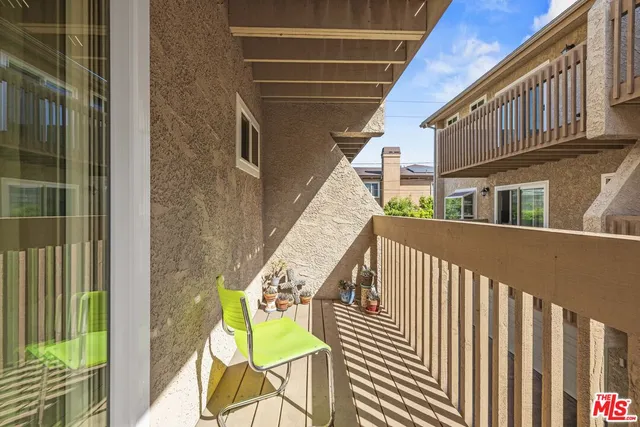a view of a chair and table in backyard of the house