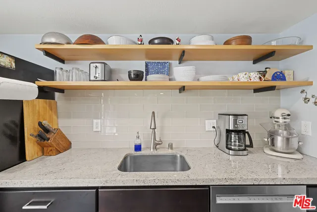 a kitchen with a sink and wooden floor