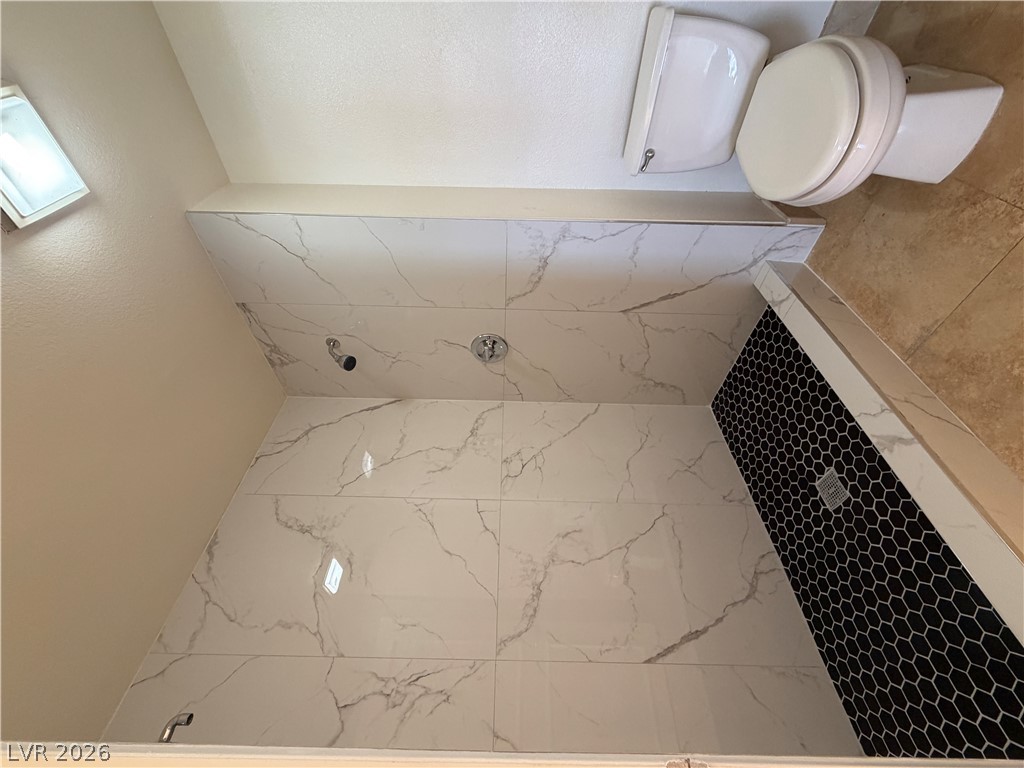 210 East Flamingo Road, Unit 126 Las Vegas, NV 89169 - Photo 10 of 16 Marble-look tile and black hexagonal accents define this contemporary shower.
