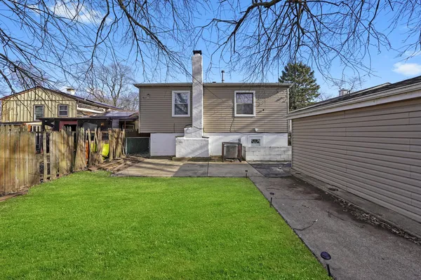 a view of a house with backyard and a tree
