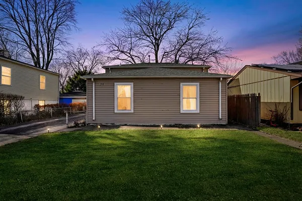 a backyard of a house with table and chairs