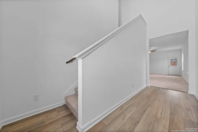 a view of hallway with stairs and wooden floor