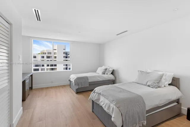 a bedroom with two beds and a large window