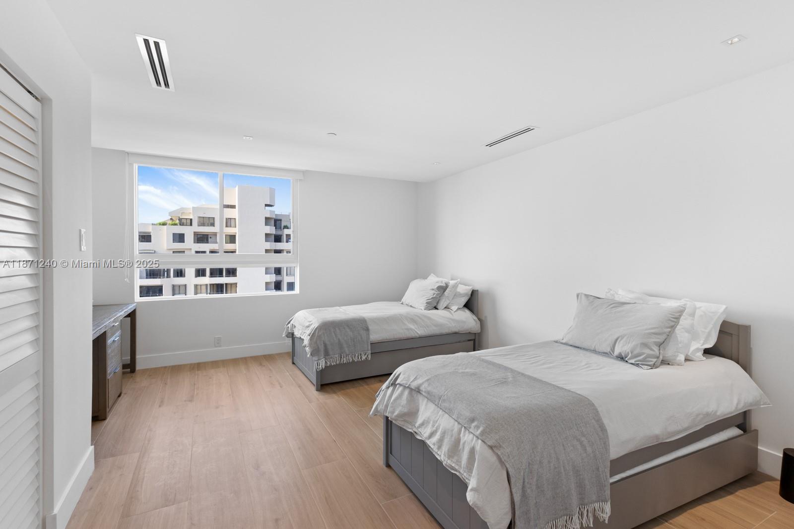 251 Crandon Boulevard, Unit 1036 Key Biscayne, FL 33149 - Photo 11 of 38 a bedroom with two beds and a large window