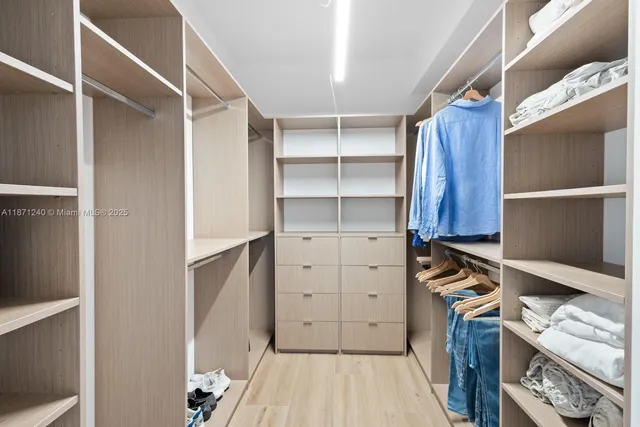 a view of walk in closet with clothes