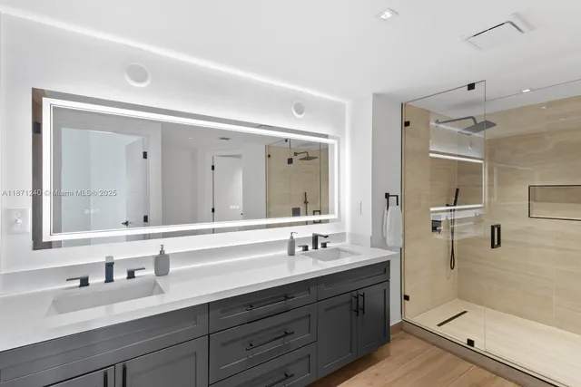 a bathroom with double vanity sinks and a mirror