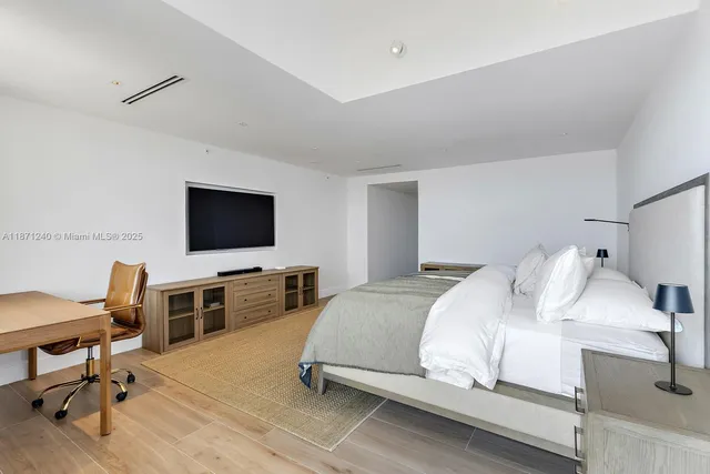 a bedroom with a bed and a flat screen tv