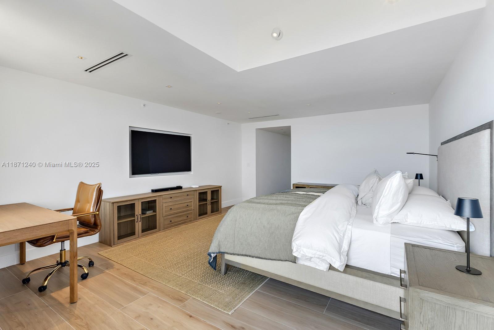 251 Crandon Boulevard, Unit 1036 Key Biscayne, FL 33149 - Photo 20 of 38 a bedroom with a bed and a flat screen tv