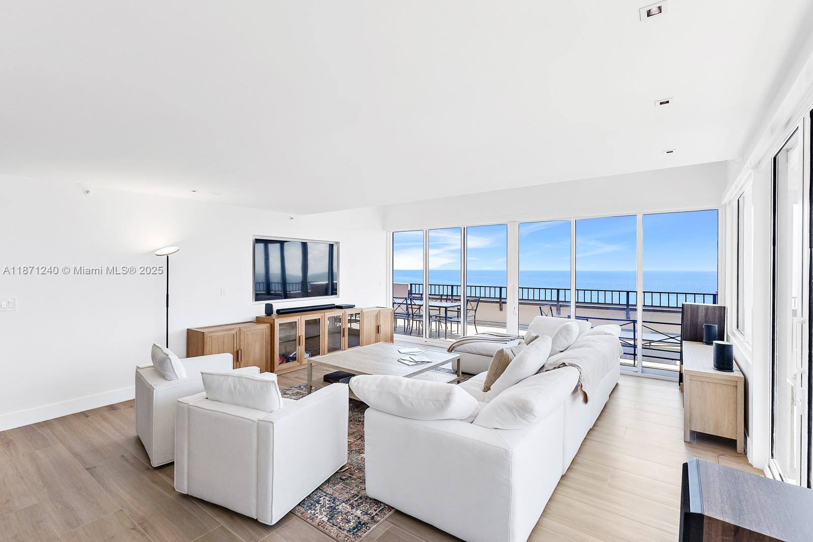 251 Crandon Boulevard, Unit 1036 Key Biscayne, FL 33149 - Photo 2 of 38 a living room with furniture large windows and wooden floor