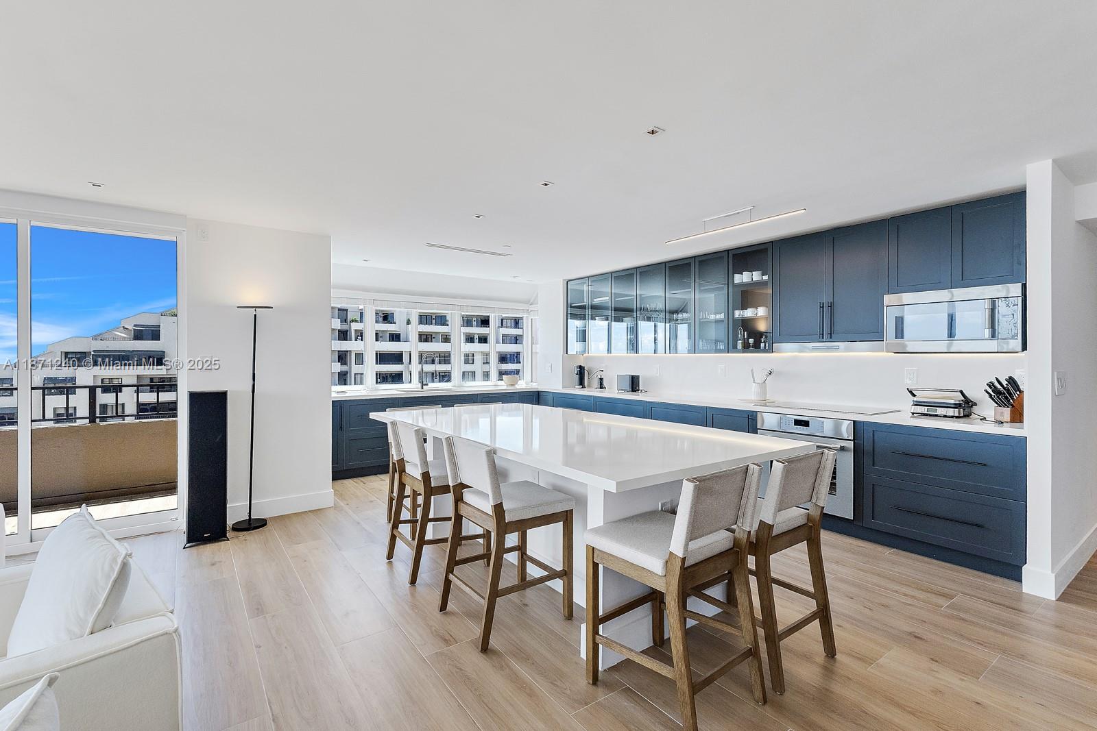 251 Crandon Boulevard, Unit 1036 Key Biscayne, FL 33149 - Photo 8 of 38 a kitchen with a table chairs refrigerator and microwave