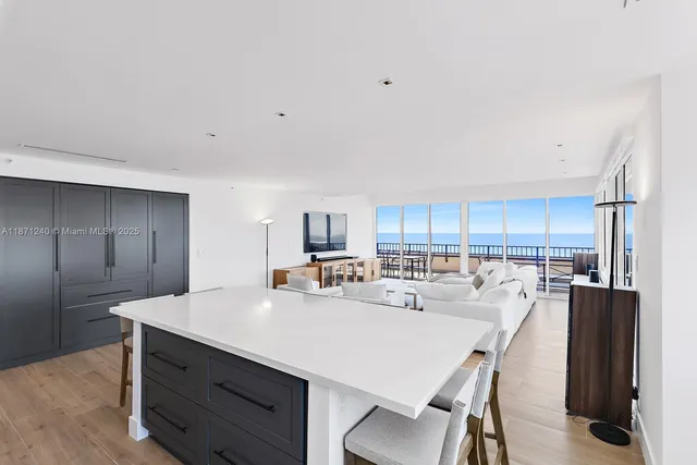 a kitchen with kitchen island a stove a sink a refrigerator and chairs