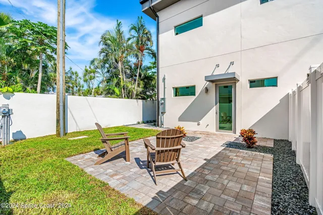 a view of backyard with table and chairs and wooden fence