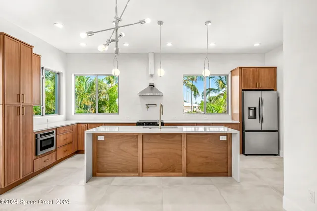 a kitchen with stainless steel appliances a stove a refrigerator and a sink