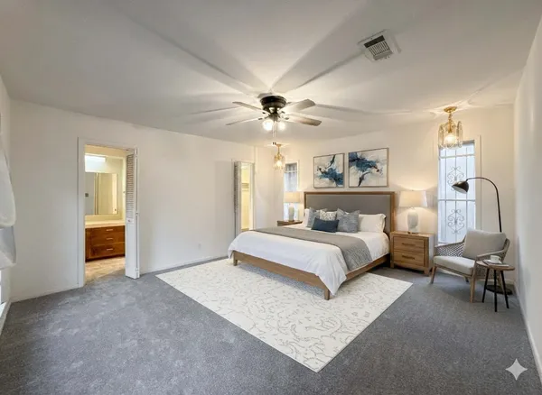 a spacious bedroom with a bed and a chandelier