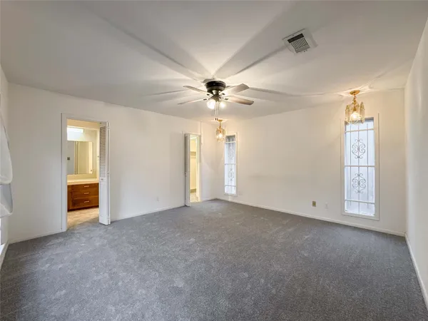 an empty room with fan and windows