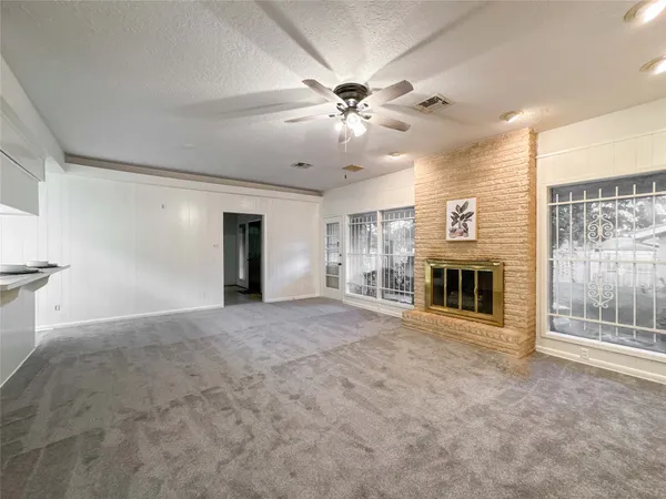 a view of an empty room with window and fireplace