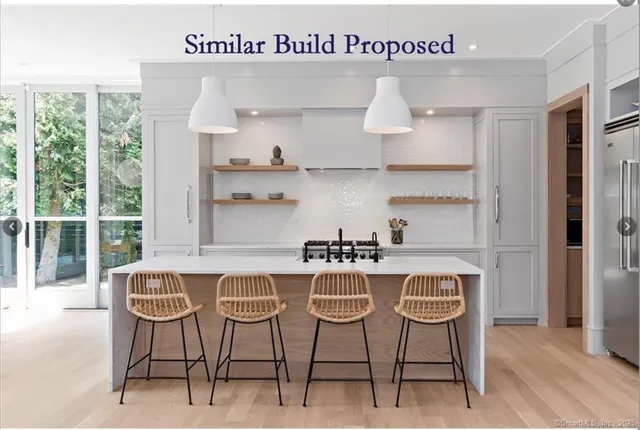 a kitchen with stainless steel appliances granite countertop a table and chairs in it