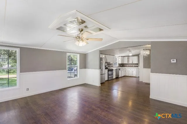 a view of a livingroom with wooden floor and a ceiling fan