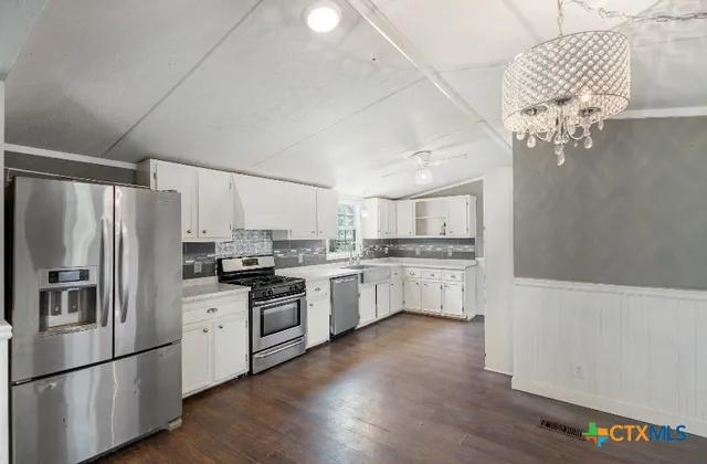a kitchen with stainless steel appliances a refrigerator sink and cabinets