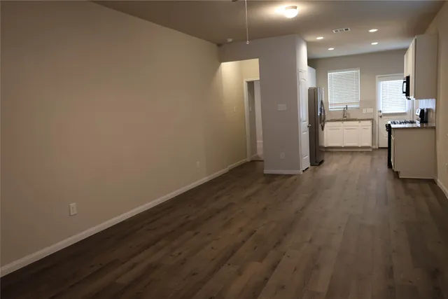 a view of a kitchen with wooden floor and electronic appliances