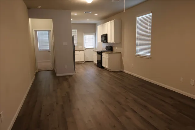 a kitchen with granite countertop cabinets stainless steel appliances a sink and wooden floor