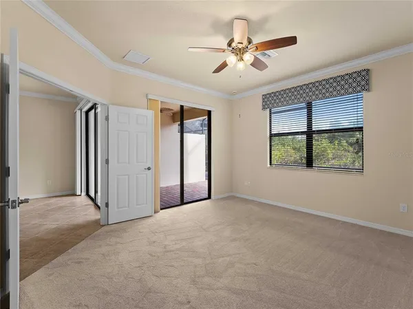 an empty room with windows and ceiling fan