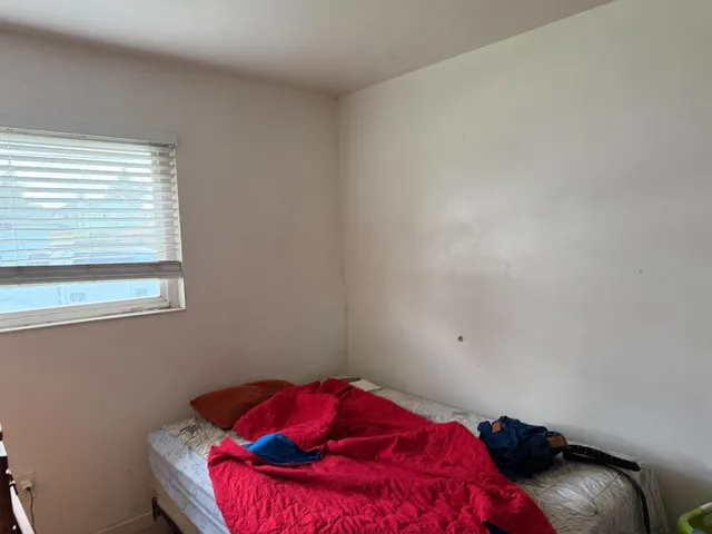 a bedroom with a bed and a window