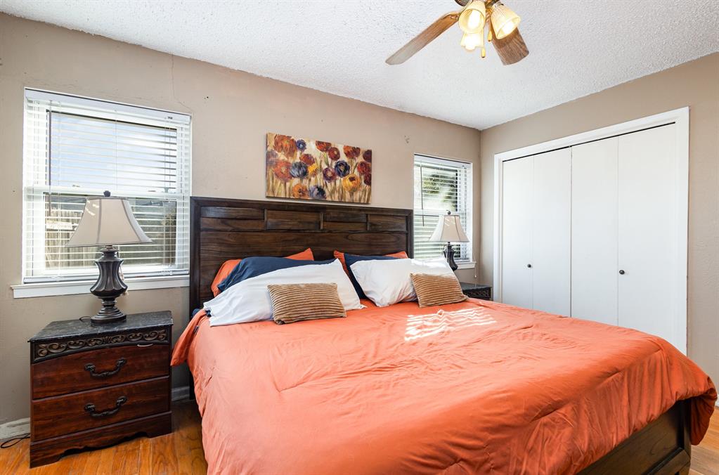 808 Ravenwood Drive Arlington, TX 76013 - Photo 14 of 27 a bedroom with a bed and wooden floor