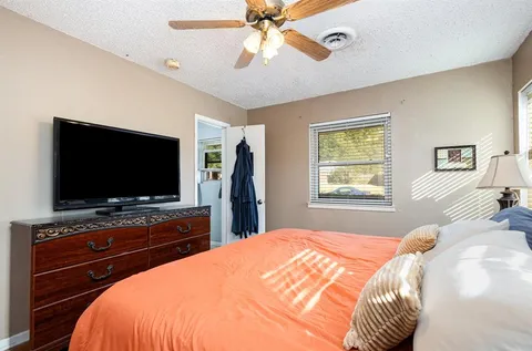 a bedroom with a bed and a flat screen tv on dresser