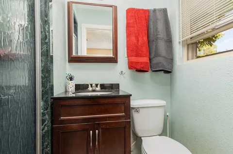 a bathroom with a toilet sink and mirror