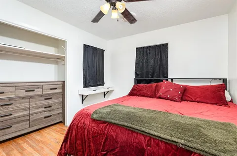 a bedroom with a large bed and a flat tv screen