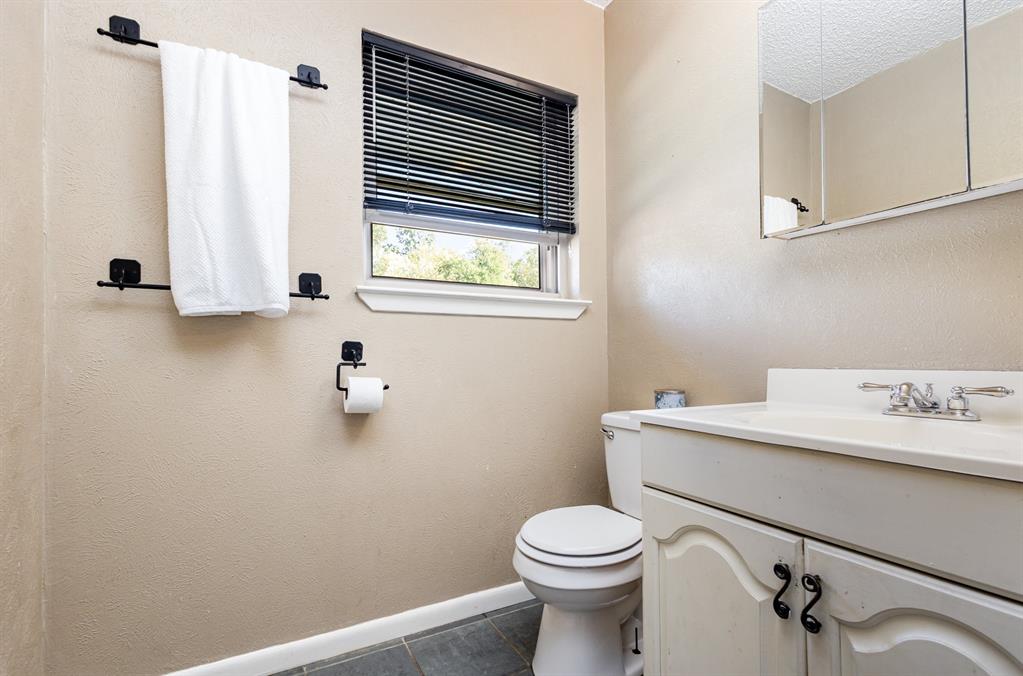 808 Ravenwood Drive Arlington, TX 76013 - Photo 19 of 27 a bathroom with a toilet sink and mirror