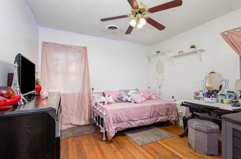 a bedroom with a bed and wooden floor