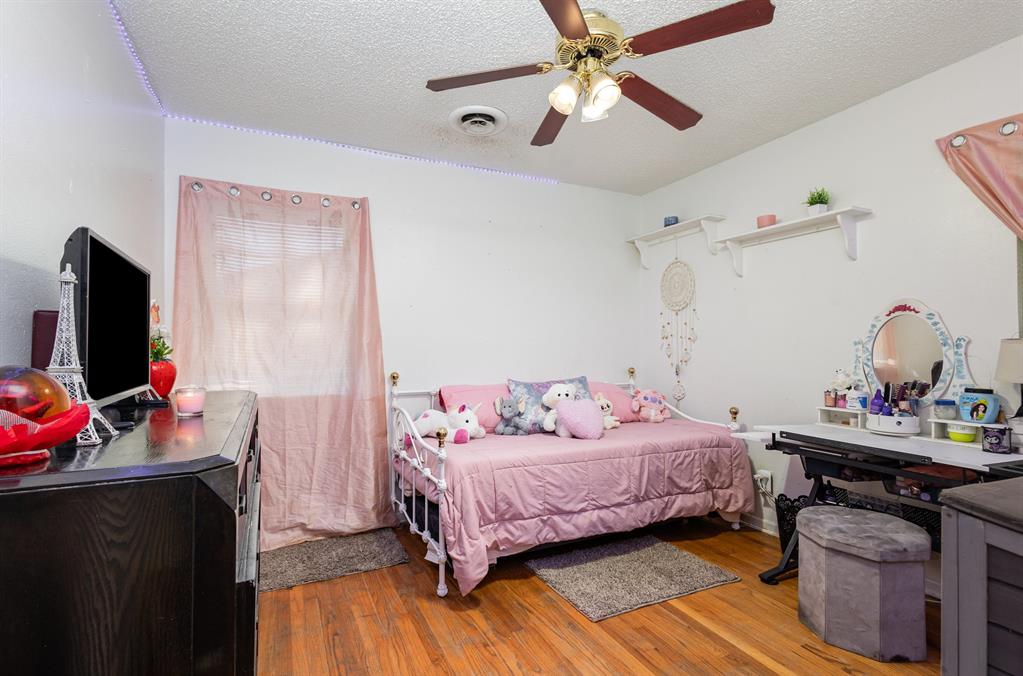808 Ravenwood Drive Arlington, TX 76013 - Photo 20 of 27 a bedroom with a bed and wooden floor