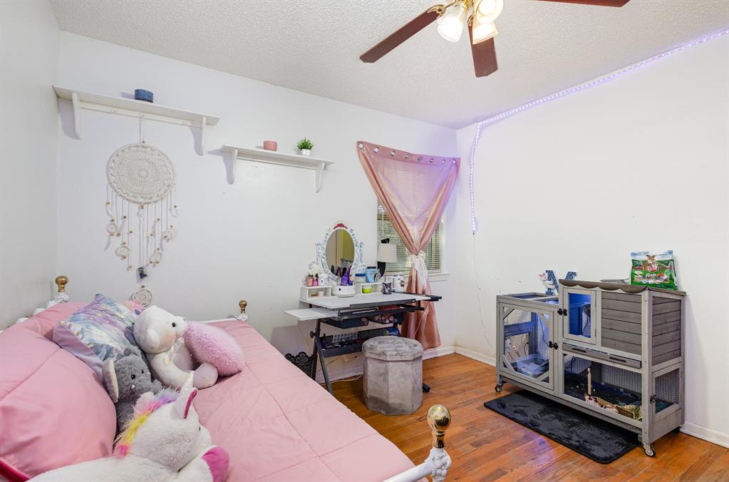 808 Ravenwood Drive Arlington, TX 76013 - Photo 21 of 27 a bedroom with furniture and a wooden floor