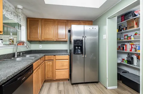 a kitchen with stainless steel appliances granite countertop a refrigerator and a sink