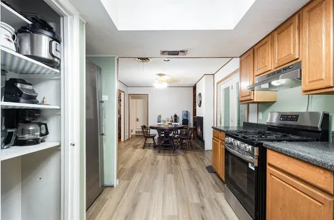 a kitchen with stainless steel appliances granite countertop a stove a sink and a refrigerator